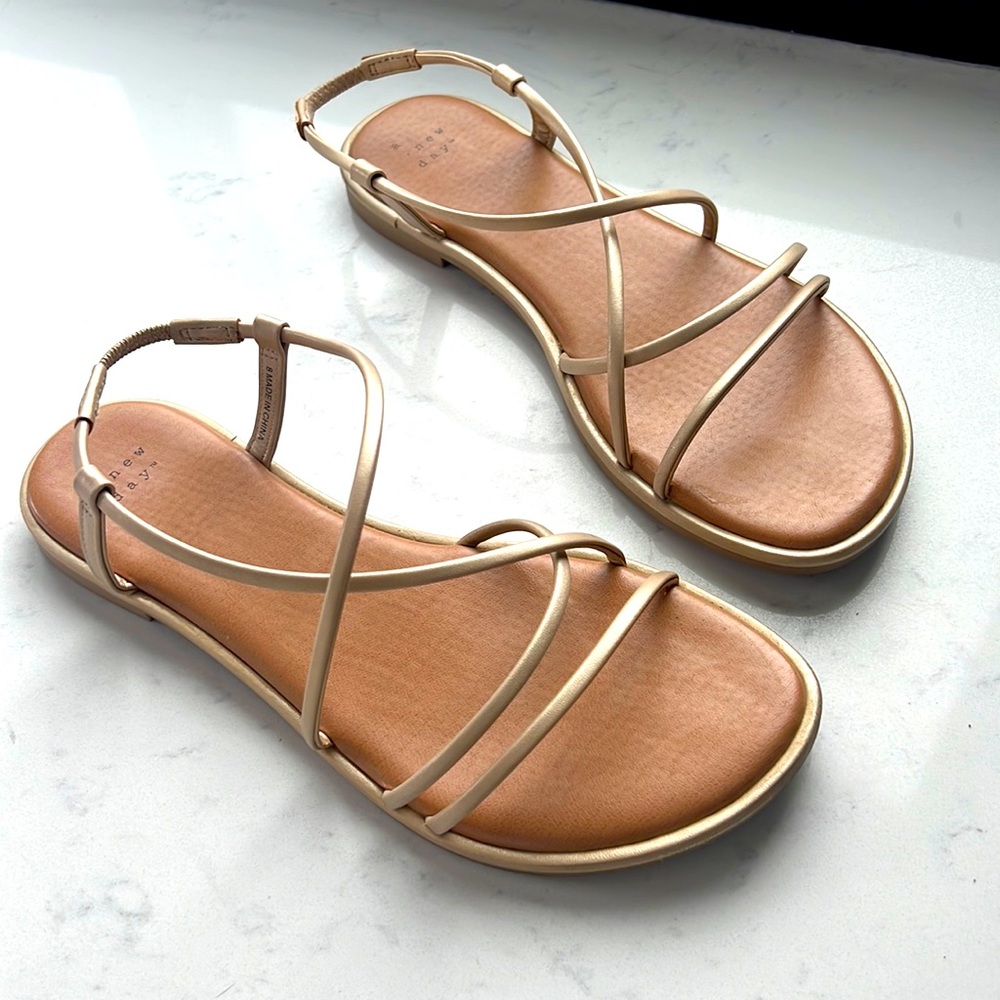 A New Day: almost new flat sandals with golden straps, size 8